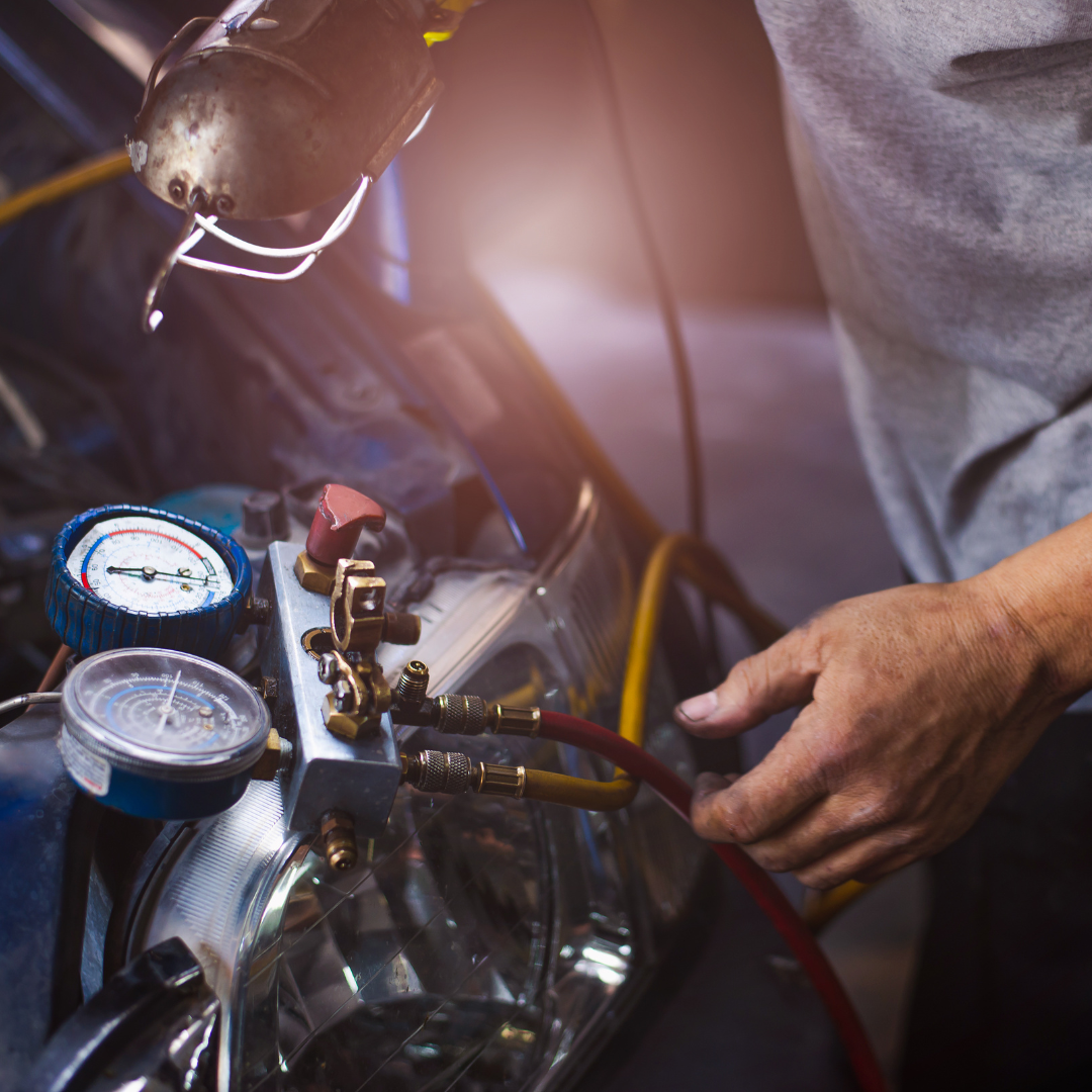 automotive mechanic working on vehicle air conditioning system